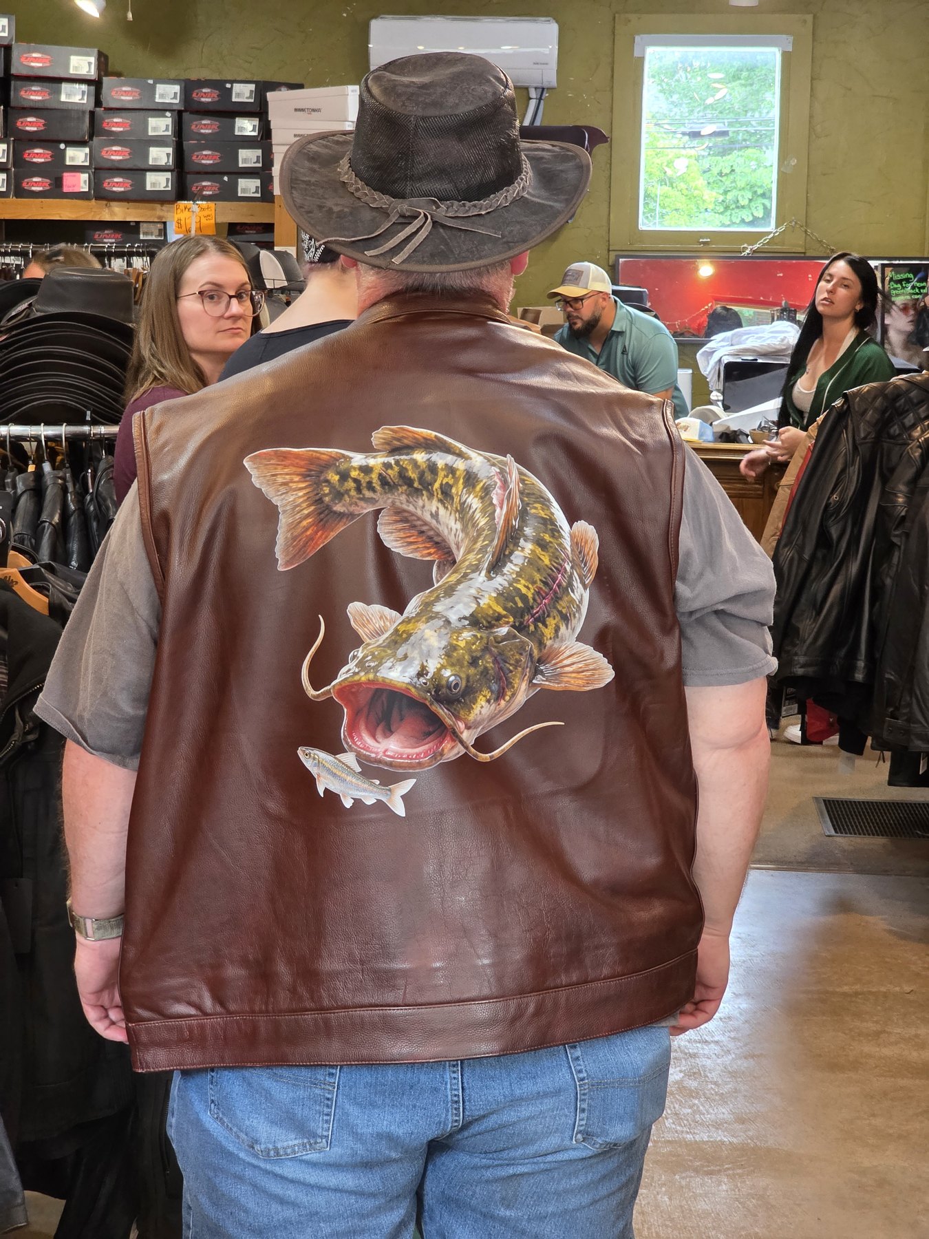 Custom painted catfish art on a brown leather vest — in-store only