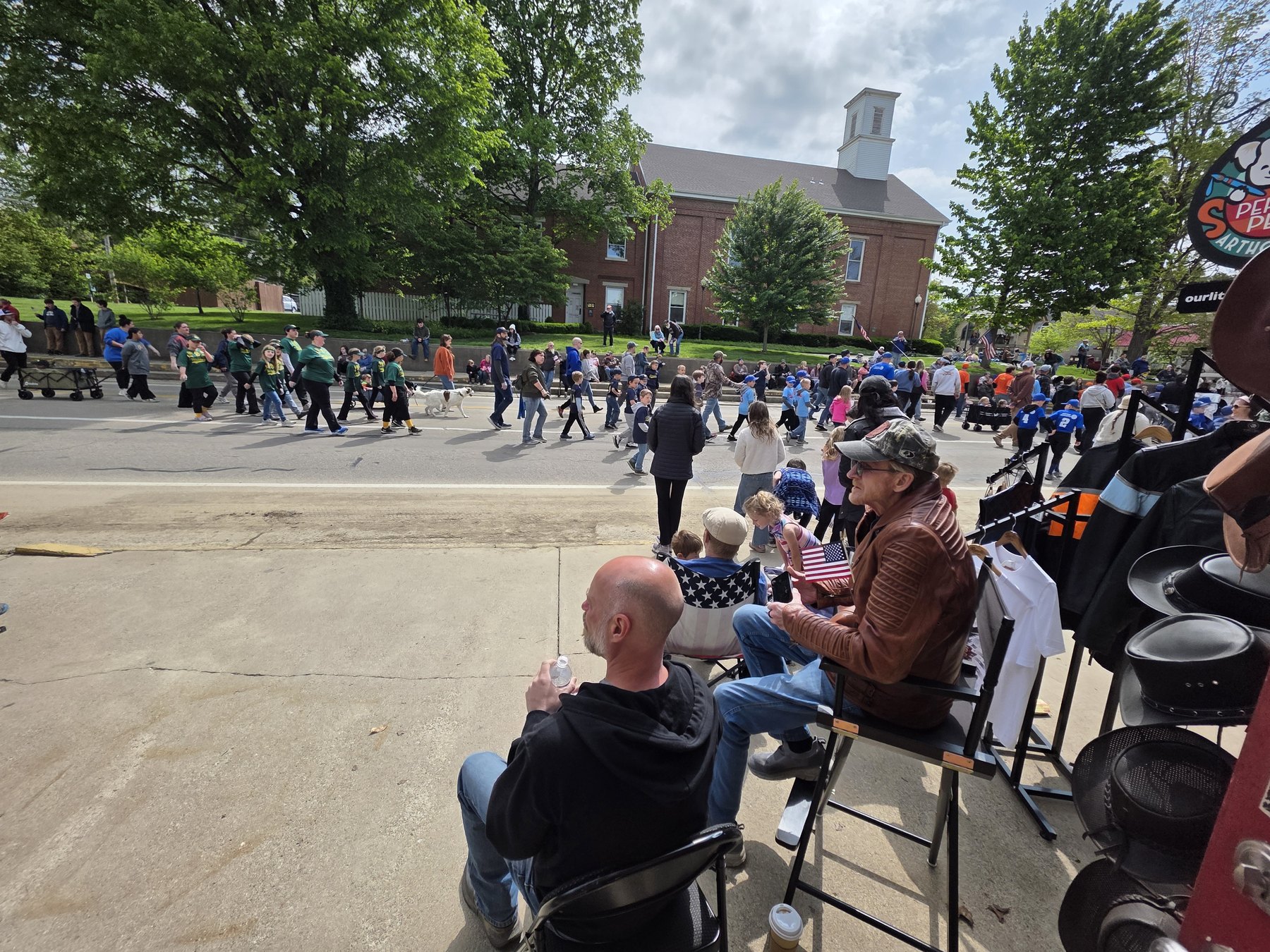 Crowd and marchers on Van Buren Street seen from the Reynolds Leather porch during the 2026 Spring Blossom Parade